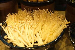 Fresh golden needle mushroom or enoki, enokitake , Flammulina velutipes in wooden plate photo