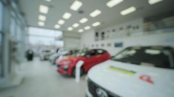 Blurred background. Car showroom for new prestigious cars. A large assortment of new cars in the showroom video
