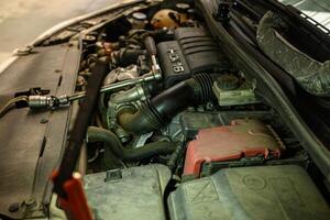 close up of vehicle engine components in a workshop automobile engine maintenance with tools visible photo
