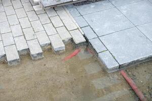 construction background. stacked paving blocks and work buckets, paver installation in progress with flexible work tubs photo
