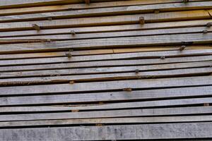 detail of raw lumber in a horizontal stack weathered wooden boards for construction sawn timber drying in layers detail of sawn timber drying in layers photo