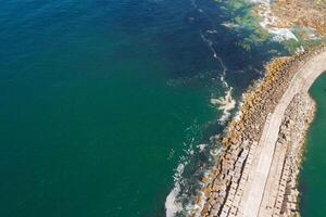 safe harbor top down view drone photography of a strategic breakwater with a beacon lighthouse photo