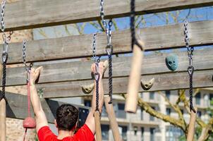 navigating a complex overhead traverse rig in an obstacle course race photo