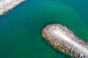 aerial view from drone of a breakwater in turquoise sea water photo