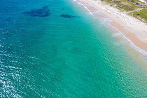 waves breaking on a deserted beach from high above. Top view. Summer concept background photo