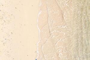 Aerial top view of beautiful tropical white sand beach with wave foam and transparent sea, Summer vacation and Travel background copy space, Top down view from drone photo