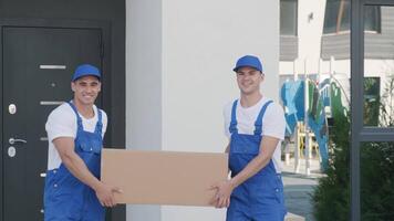 Two young workers of removal company are loading boxes and furniture into a minibus 15 video