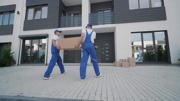 Two young workers of removal company unload boxes and furniture from minibus into customer's home 11 video