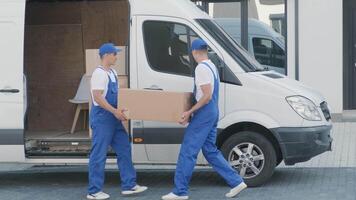 Two young workers of removal company unload boxes from minibus into customer's home 4 video