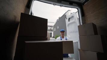 Two young workers of removal company are loading boxes and furniture into a minibus 62 video