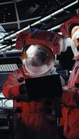 Vertical Astronaut waves hand during videocall with Earth command center while aboard spacecraft, sharing mission update. Cosmonaut salutes researchers during communication link to ground center, camera A video