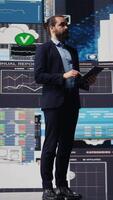 Vertical Surrounded by virtual graphs and forecasting models, chief executive officer uses financial data and insight to drive business growth. Ensuring performance and smart decision making. Camera B. video