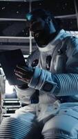 Vertical Astronaut doing hand gestures while taking selfies with smartphone inside space station during exploration mission. Man takes pictures with mobile phone during cosmic expedition, camera A video