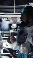 Vertical Astronaut taking selfie pictures with smartphone, making hand gestures during planet colonization mission. Orbit station crew member doing photographs with mobile phone during cosmic journey, camera A video