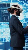 Vertical Business IT expert employing vr glasses and artificial intelligence brain, working on data visualization cybernetics within interface for machine learning. High tech gadget for innovation. Camera B. video