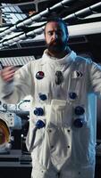 Vertical Close up of astronaut using tablet to check Mars telemetry data during human expansion in space mission. Cosmonaut in starship analyzes red planet surface supporting mankind survival, camera A video