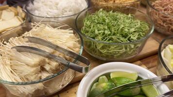 set for making Vietnamese soup with enoki mushrooms and other green sprouts in the buffet selection video