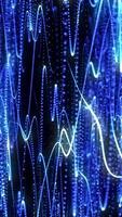 Dynamic abstract image of glowing blue particle waves and light trails over a dark background, evoking data streams and futuristic motion video