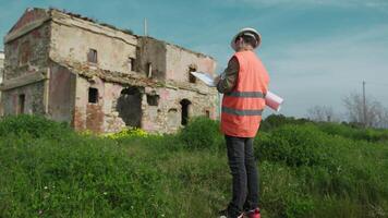 Engineer On The Construction Site Looking At The Old Building And Taking Notes video