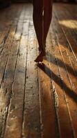 Barefoot dancer on old wooden floor in warm light photo