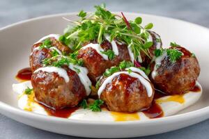 Delicious meatballs resting on yogurt sauce, garnished with microgreens and parsley photo