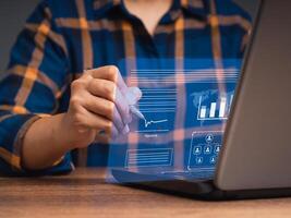 Close-up of a businessman uses a pen to sign digital documents on a virtual screen while sitting at the table photo