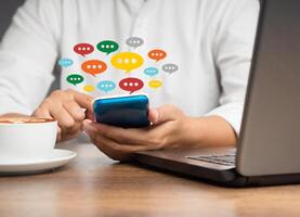 Close-up of hands using mobile phone with colorful chat icons on application communication digital photo
