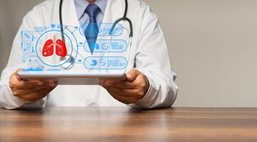 Physician reads a lung examination report on a tablet virtual display while sitting in a hospital photo