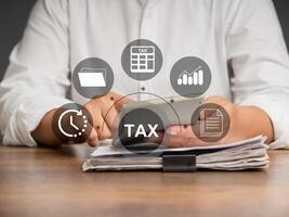 Businessman using a calculator to calculate tax while sitting in the office photo