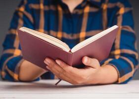 A man reading a book while sitting at the table photo