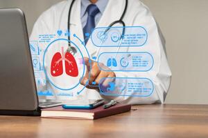 Doctor reads a lung examination report on a laptop virtual display while sitting in a hospital photo