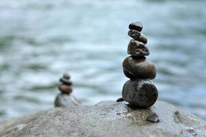 Rock stacking or rock balancing in river blur background photo
