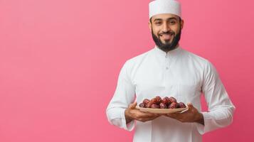 Arab man holding plate of dates. photo