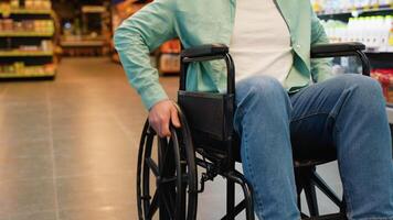 Man in wheelchair moving through supermarket aisles video