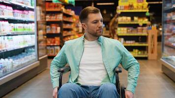 Customer sitting in wheelchair looking at shelves in supermarket video