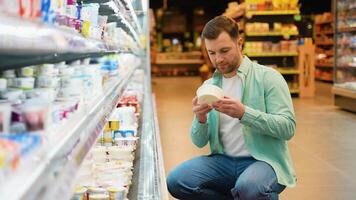 Customer choosing yogurt in dairy section of supermarket video