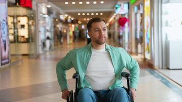 Customer sitting in wheelchair looking around modern shopping mall video