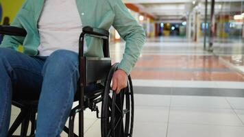Man in wheelchair moving through shopping mall corridor video
