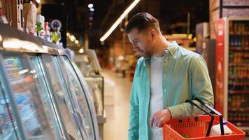 Customer choosing frozen food in supermarket refrigerator video