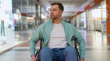 Happy person with disability sitting in wheelchair in shopping mall video