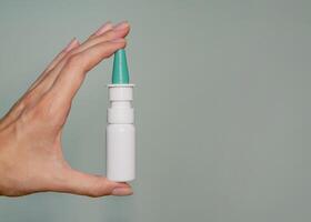 A nasal spray in woman's hand close up. Background banner with copy space for text photo