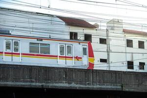 Train crossing a bridge in an urban setting photo