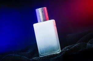 Elegant Perfume Bottle with Silver Cap Under Blue and Red Lights photo