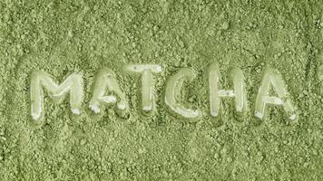 Top view of organic matcha powder with MATCHA text written in powder. Minimal healthy drink concept. Trendy japanese green tea idea. Flat lay style. photo
