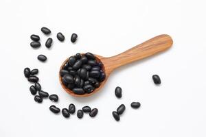 black bean on a wooden spoon on a white background photo