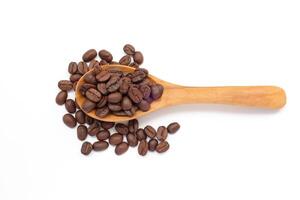 Brown coffee beans on a wooden spoon on a white background photo