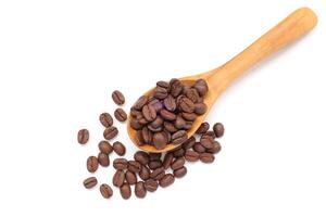 Top view of Coffee beans in spoon, brown roasted coffee beans in wooden spoon on white background photo