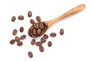 Coffee beans in spoon on white photo