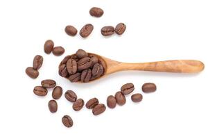 coffee beans scattered on a wooden spoon on a white background photo