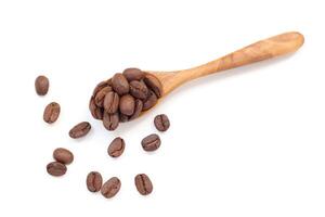 Top view of coffee beans on a wooden spoon isolated on white background photo
